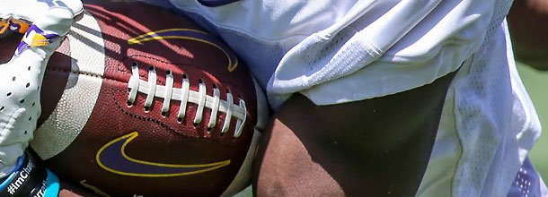 An American football is held by a player