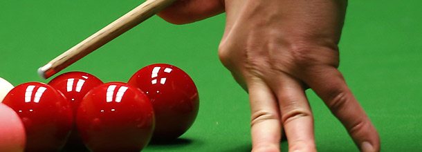 A snooker player plays a tricky shot